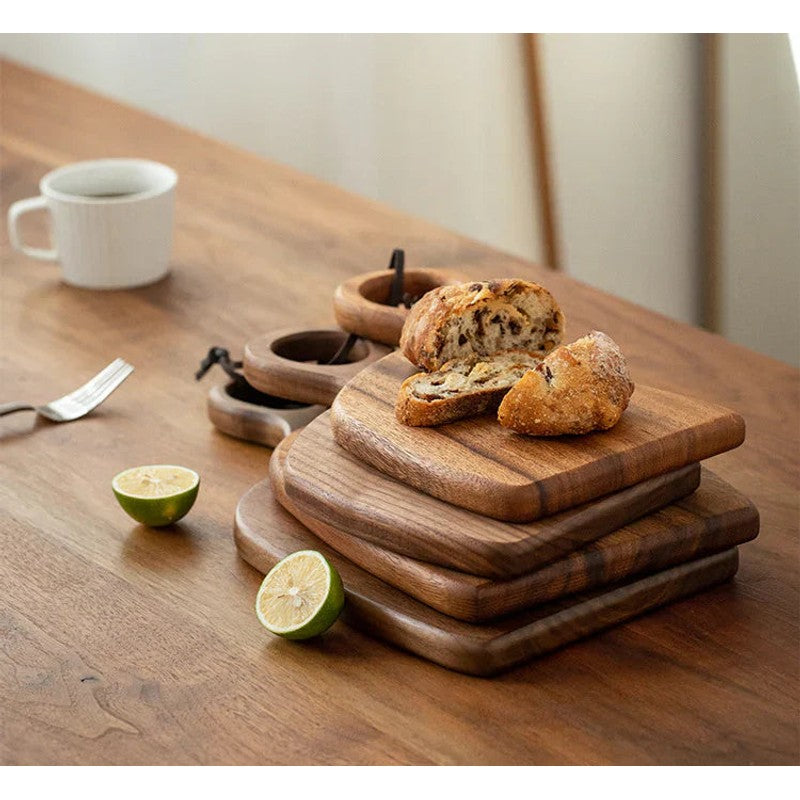 Accesorios de cocina: tabla de cortar asimétrica de madera con asa para preparación y servir comida gourmet.
