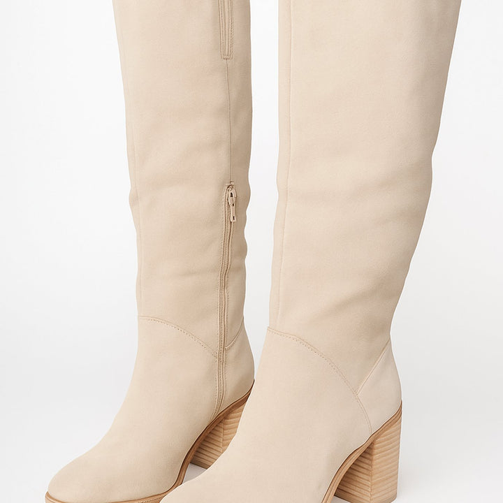 Botas altas de mujer color beige con tacón grueso. Material efecto ante, ideal para looks elegantes de invierno.