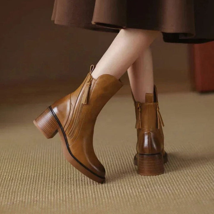 Mujer usando botines de tacón ancho. Calzado cómodo y de moda con estilo urbano, ideal para el otoño.