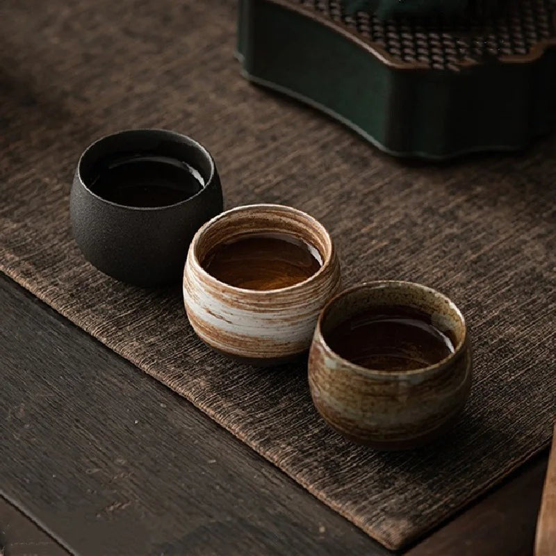 Taza de café artesanal redonda de gres sin asa, ideal para el hogar.