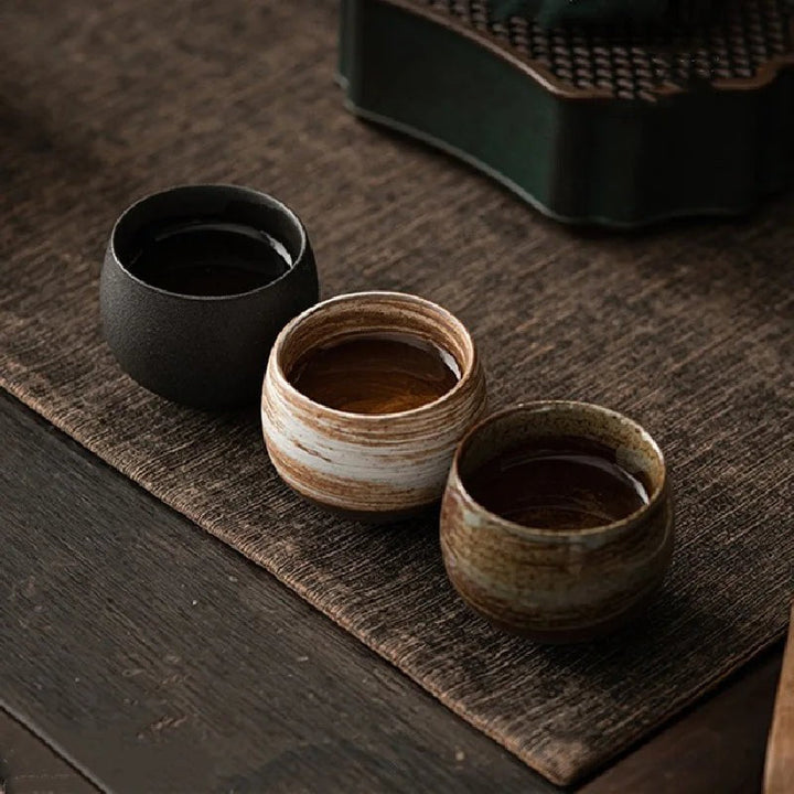 Taza de café artesanal redonda de gres sin asa, ideal para el hogar.