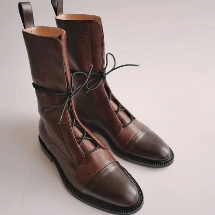 Primer plano de la puntera reforzada y cordones de las botas militares urbanas negras para mujer.