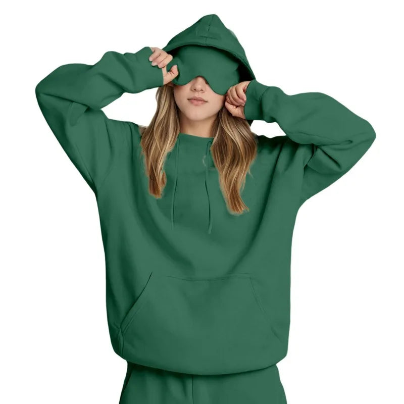 Mujer vistiendo sudadera de viaje multifuncional. Máscara integrada para relajación.