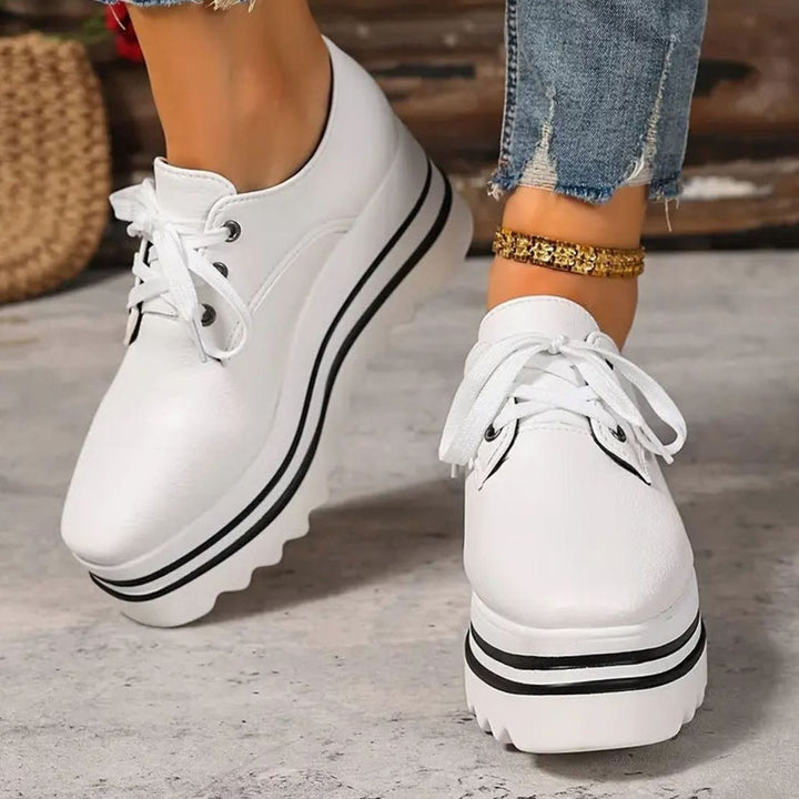 Primer plano de zapatillas Oxford plataforma para mujer, detalle de cordones y puntera cuadrada.