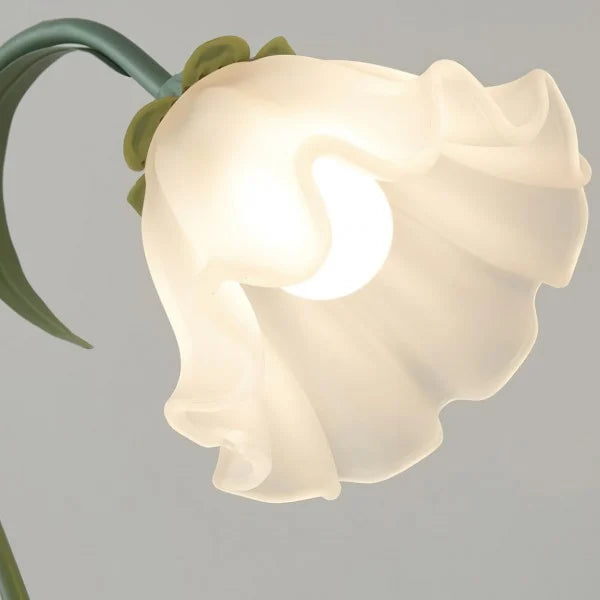 Elegante lámpara de mesa floral blanca vintage, brazo ajustable, para un dormitorio chic.