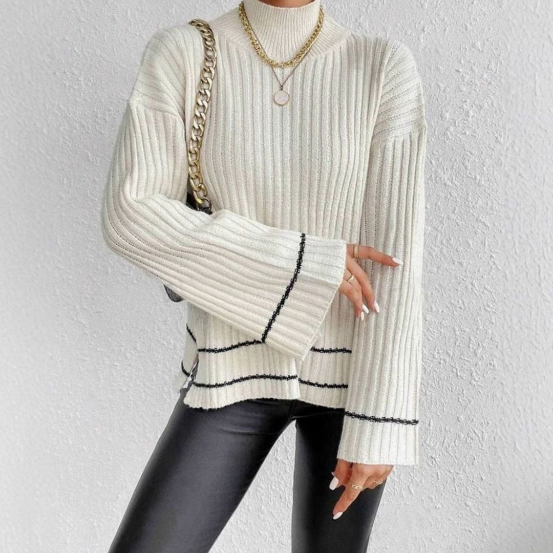 Jersey de mujer de punto canalé con rayas, cuello alto y mangas acampanadas. Prenda cómoda y elegante.