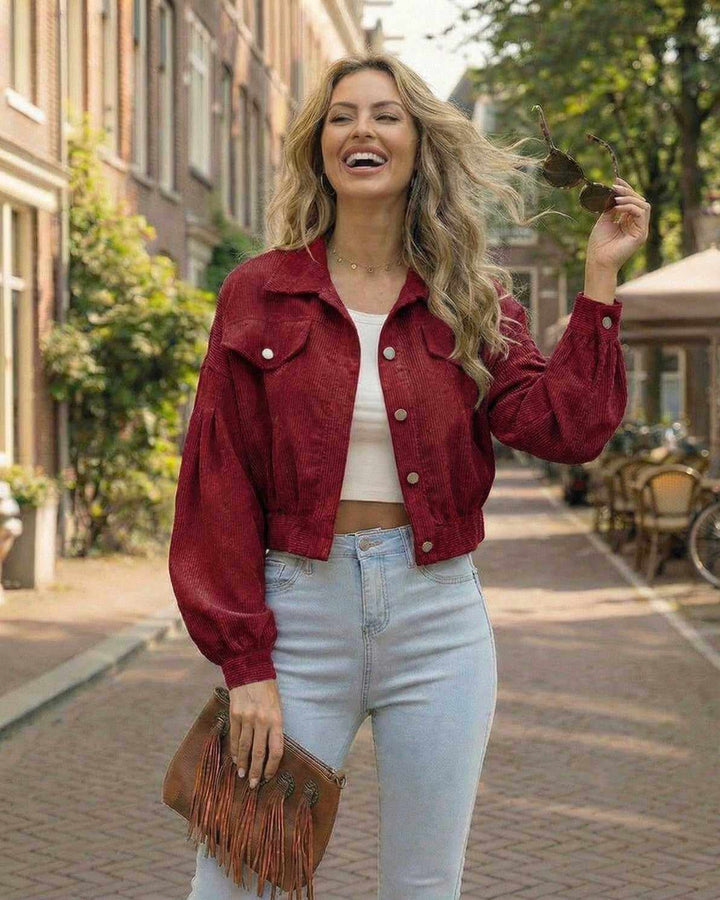 Estilosa chaqueta roja recortada de mujer. Diseño contemporáneo con mangas de linterna, ideal para moda urbana.