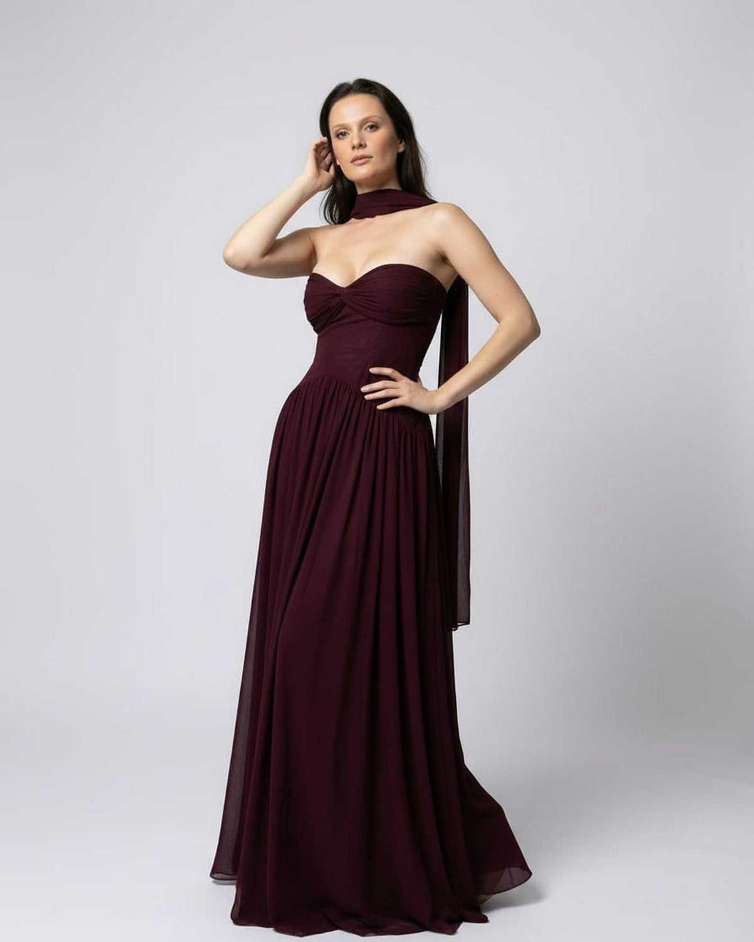 Vestido de noche maxi burdeos sin tirantes para mujer, con diseño elegante y tela fluyente para eventos.