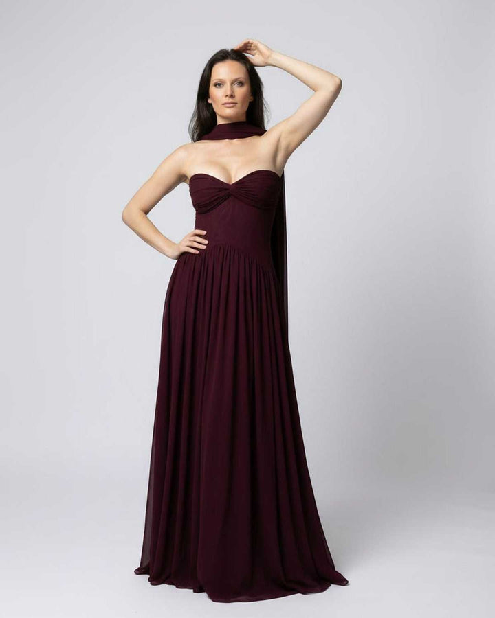 Vestido maxi burdeos fluyente sin tirantes, con silueta elegante para mujer, ideal para fiestas y celebraciones.