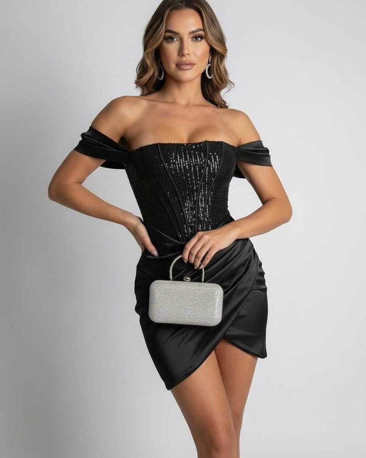 Sofisticado vestido mini negro ajustado de lentejuelas y hombros al descubierto. Perfecto para eventos de noche o cóctel.