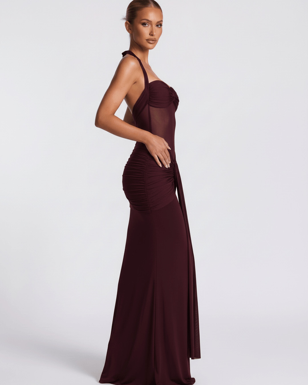 Vestido burdeos de noche, cuello halter, silueta ajustada de sirena. Moda formal para mujer.