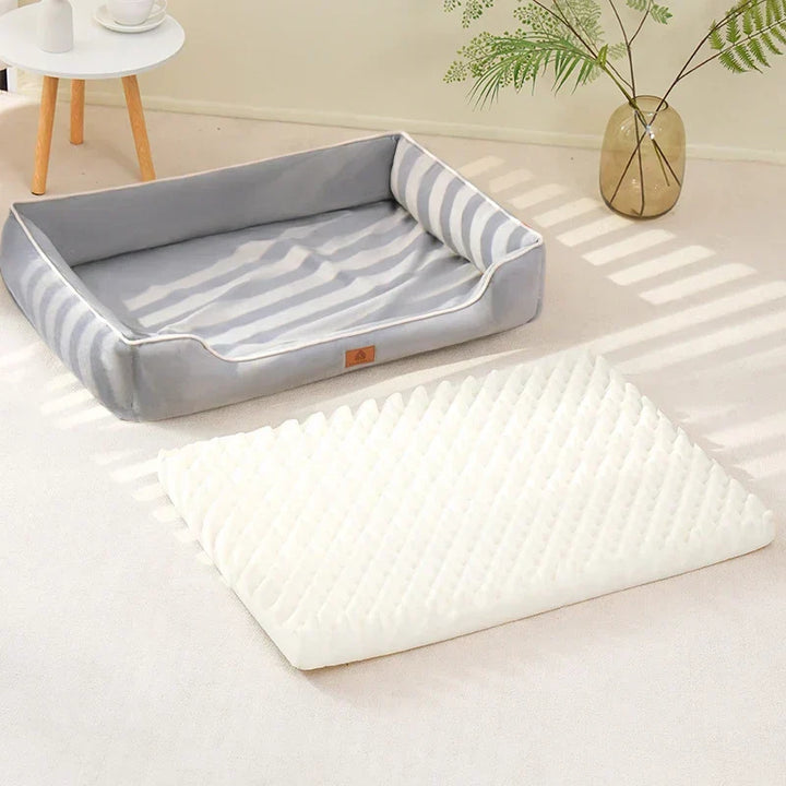Cama de terciopelo color gris con cojín para mascotas, brindando un espacio de descanso confortable.