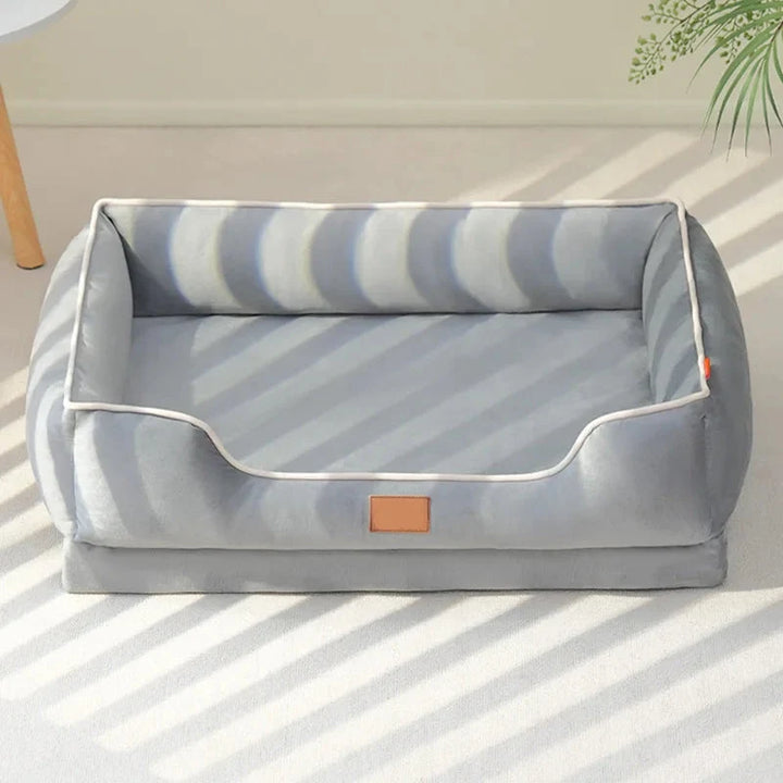 Cama para perros y gatos con respaldo alto y cojín removible, ofreciendo un descanso premium a tu mascota.