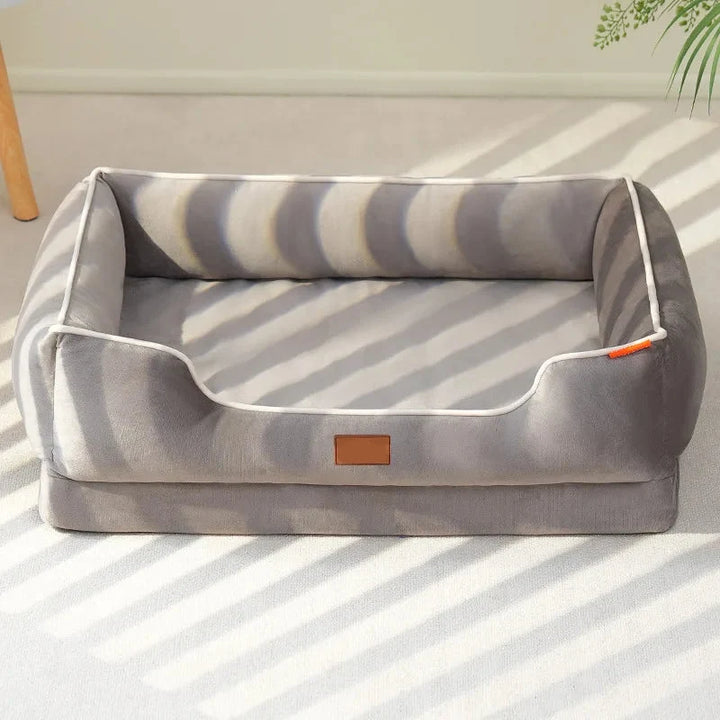 Mascota durmiendo plácidamente en la cama suave de terciopelo con respaldo, para un confort animal total.