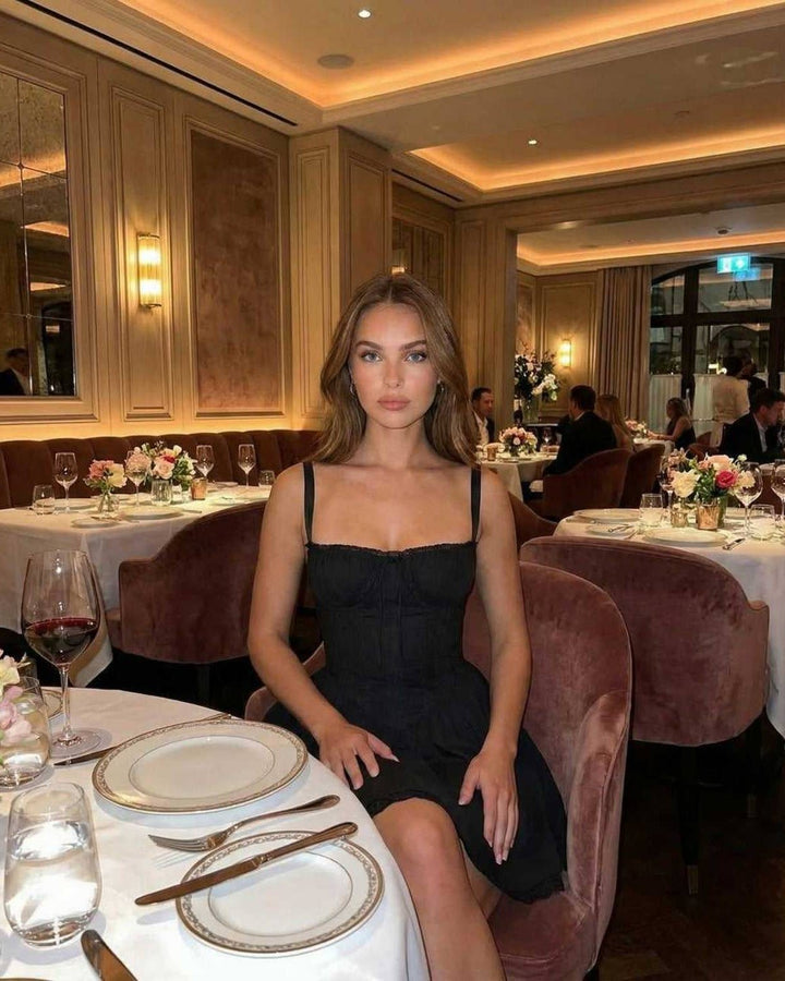 Vestido mini negro sofisticado de noche con corsé y encaje. Silueta femenina y diseño moderno.