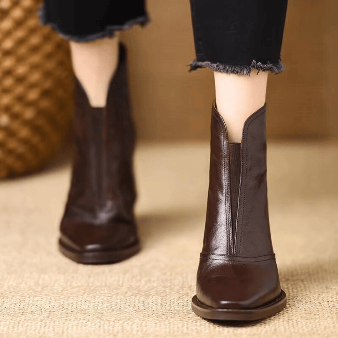 Detalle de botas de mujer al tobillo con tacón ancho y cremallera. Calzado de moda con estilo urbano.