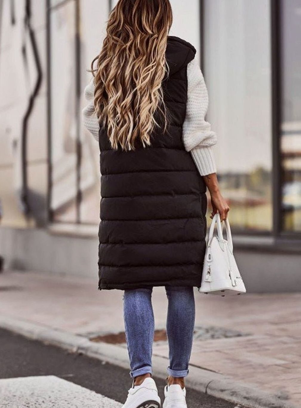 Chaleco puffer largo acolchado para mujer, con capucha. Diseño moderno sin mangas para un look de invierno.