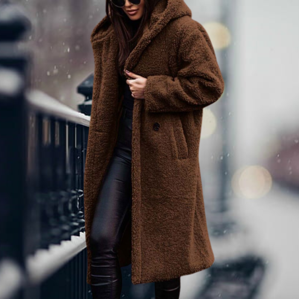 Moda de invierno: Mujer vistiendo abrigo cálido y con capucha, ideal para un estilo urbano. [[lstfy-media:7]]