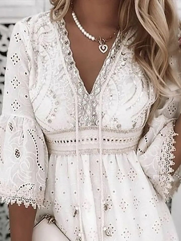 Mujer luce vestido mini bohemio con escote en V profundo y mangas acampanadas. Estilo fresco para moda de verano.