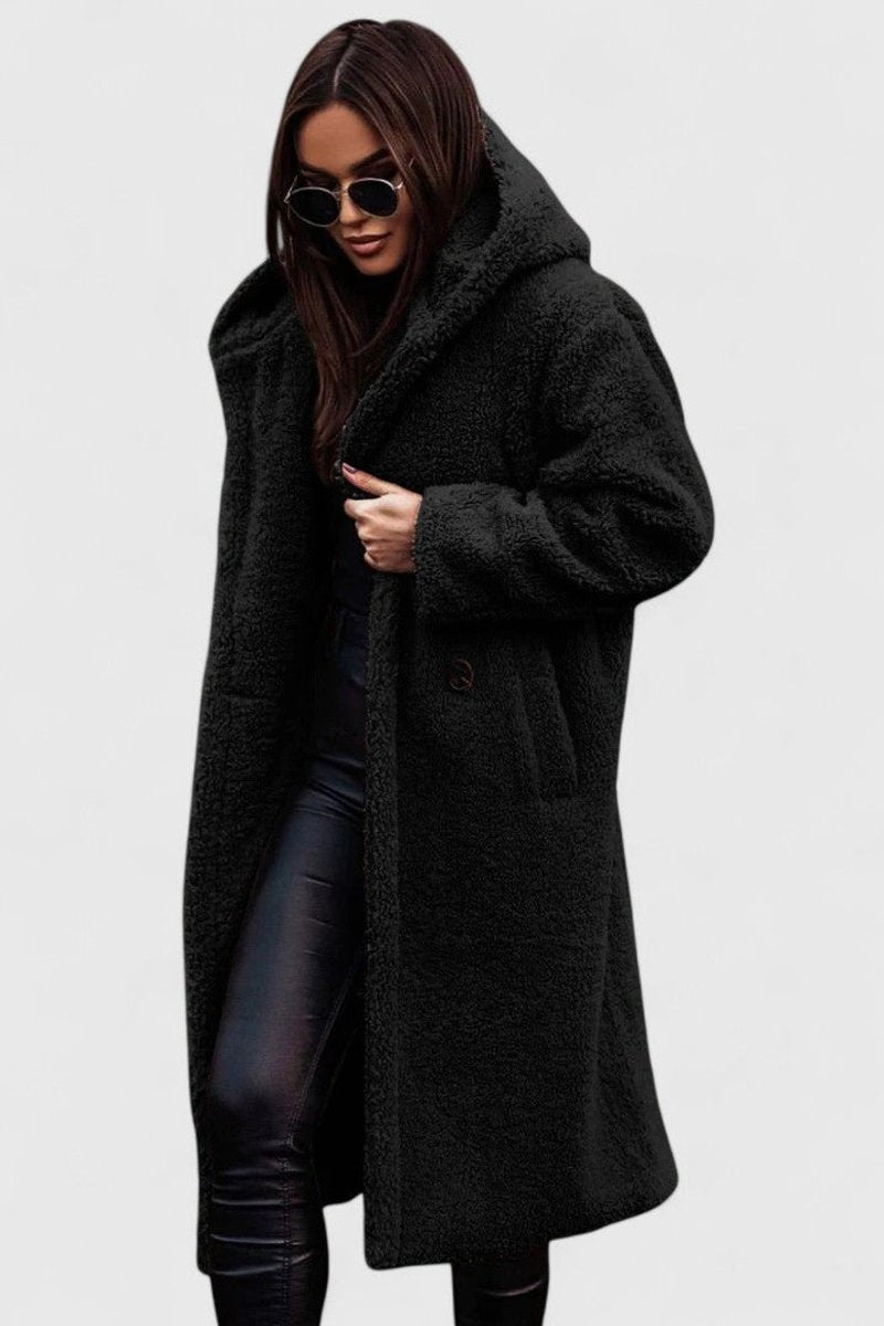 Detalle de abrigo largo para mujer, esencial en invierno. Comodidad y sofisticación en moda casual.