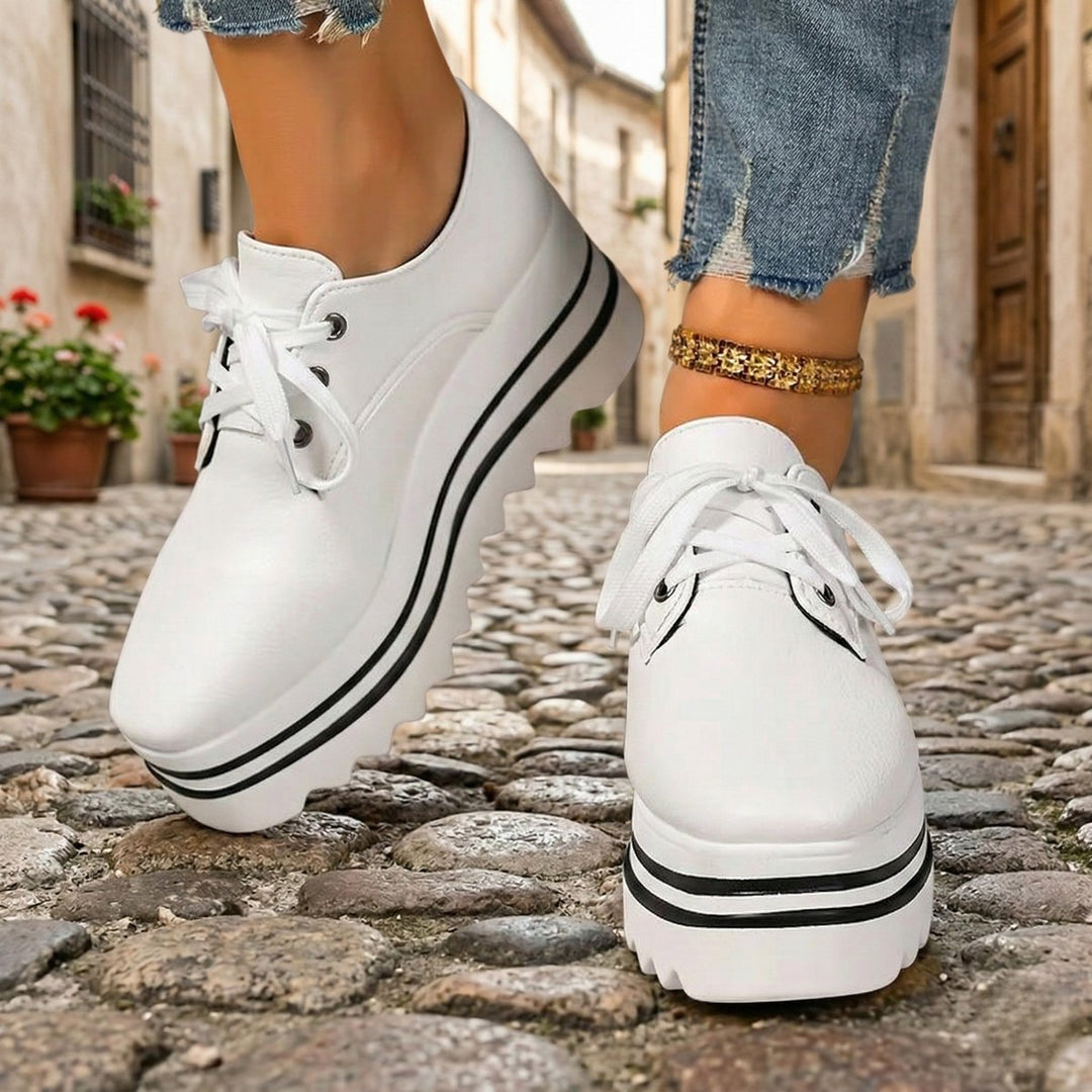 Mujer posando con botines Oxford de plataforma, mostrando estilo, elegancia y ajuste perfecto del calzado femenino.