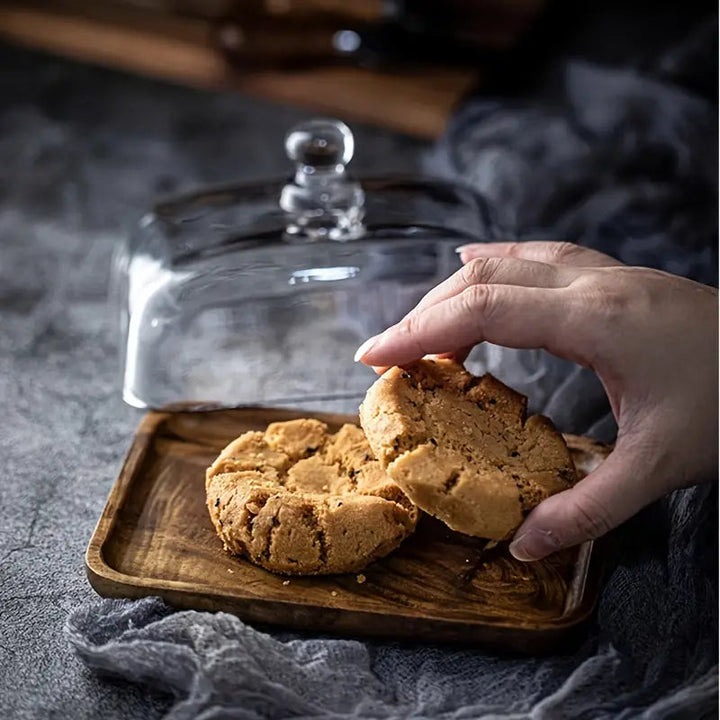 Recipiente para mantequilla con base de madera y tapa de vidrio, perfecto para mesa y hogar elegante.