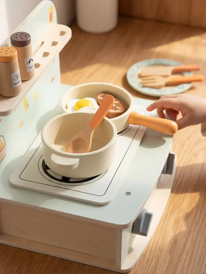 Elegante mini cocina de madera natural para niños, con perillas giratorias y acabados seguros para el juego.