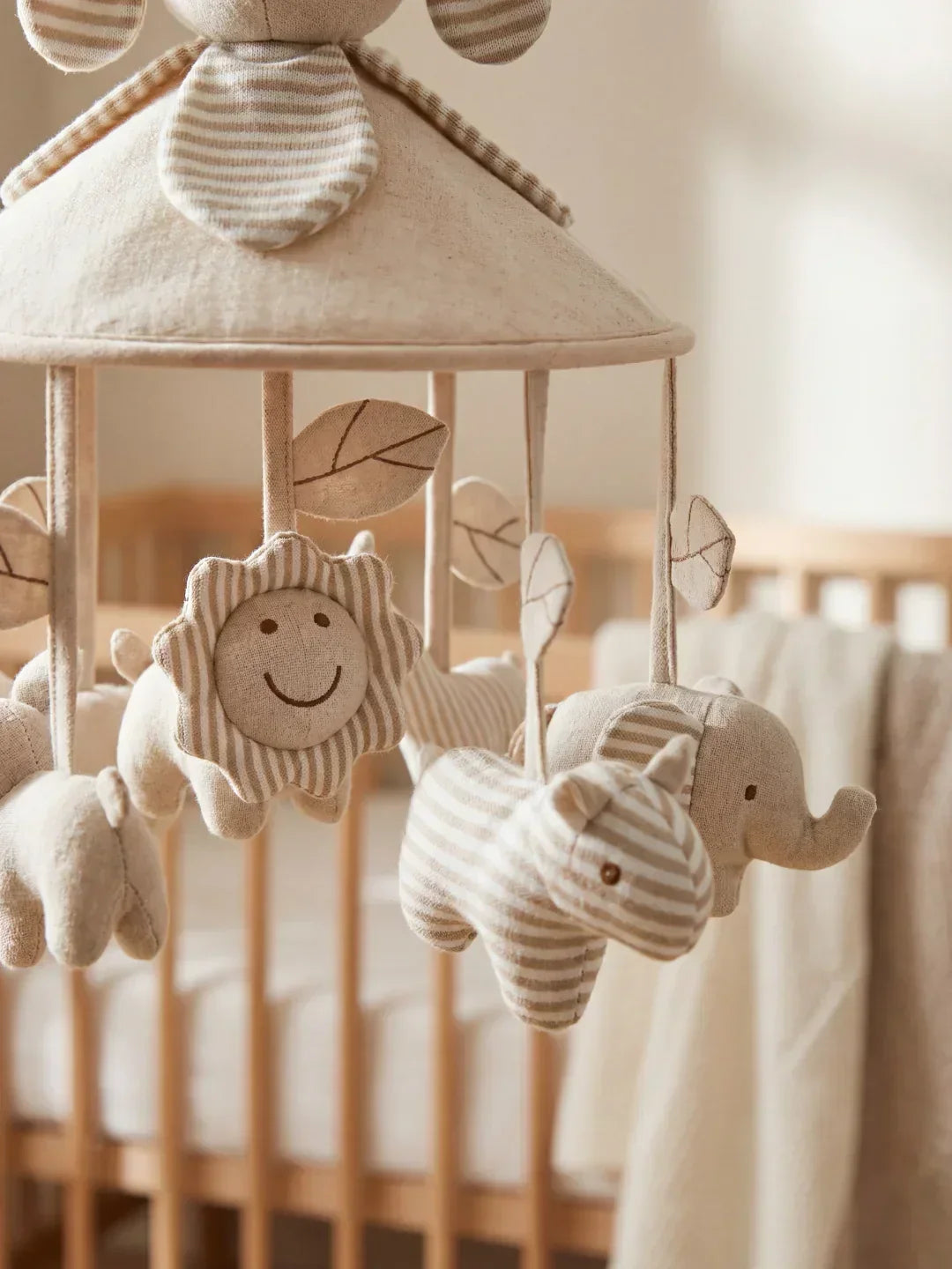 Móvil de cuna musical para bebé de madera natural, con figuras colgantes y acabados suaves.